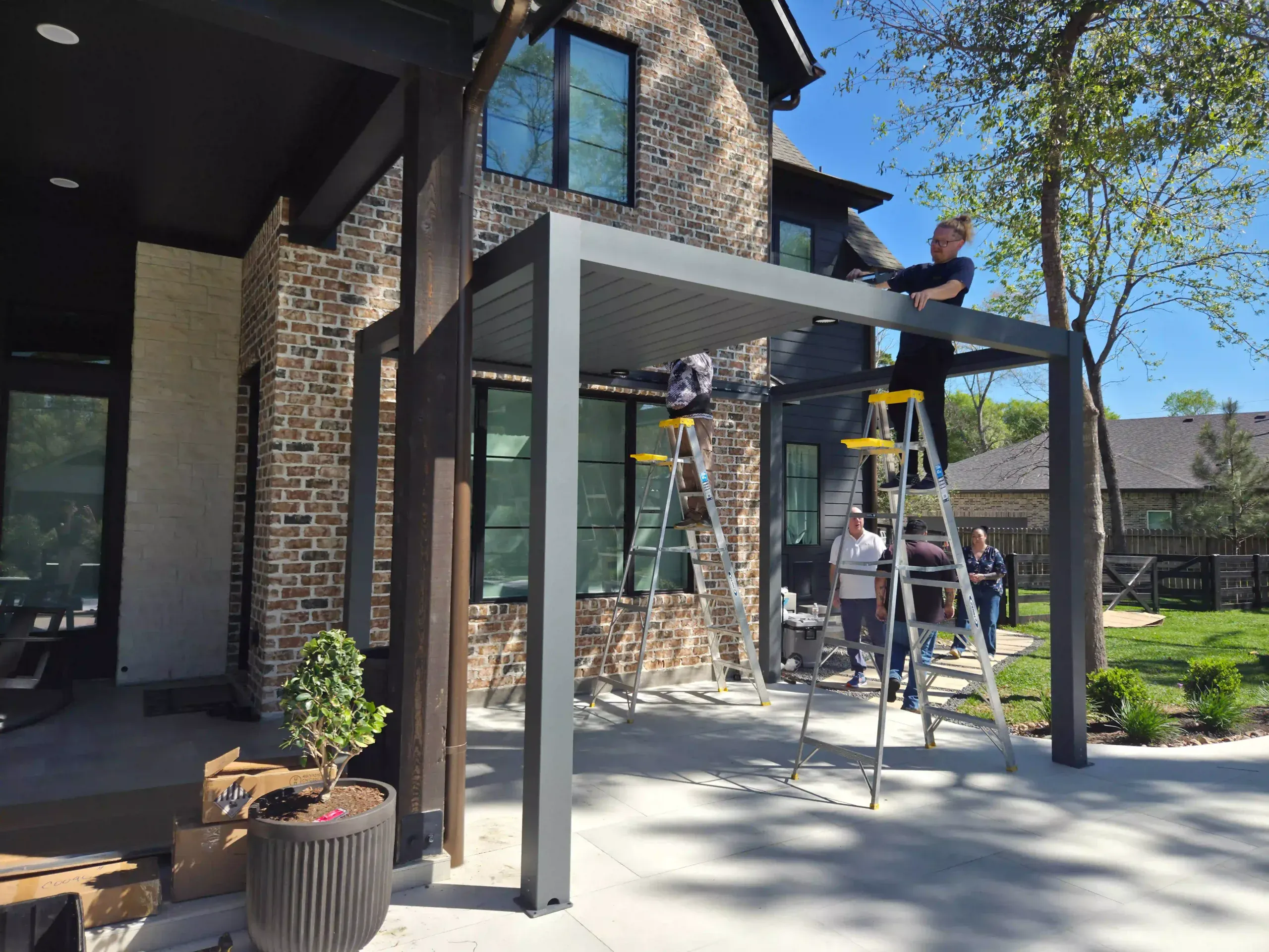 DIY pergola installation by residential home with 3-person assembly team