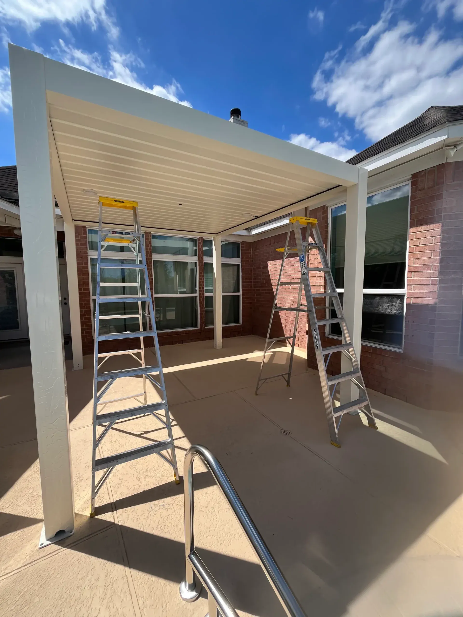 AT Louvre pergola being installed on concrete pool deck